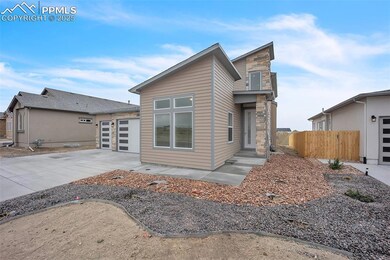 Back of property with driveway and a garage