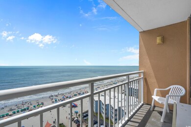Balcony featuring view of water and beach