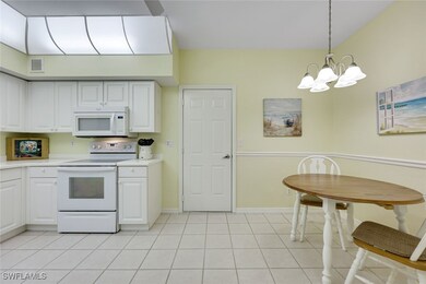 Kitchen with light tile patterned floors, white ap