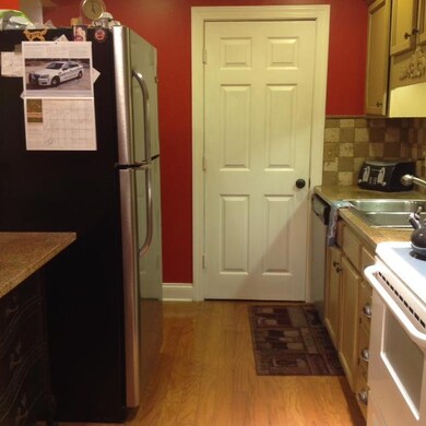 Galley Style Kitchen with Hardwood Flooring, Granite Countertops, Nice Backsplash!  Smooth Top Stove, Microwave, Dishwasher and Refrigerator to Remain!