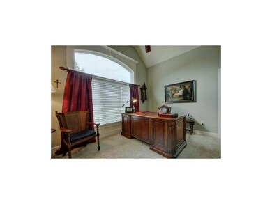Main floor office/bedroom with focal window and va