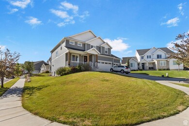 View of front of home featuring covered porch, a residential view, a front lawn, asphalt driveway, and an attached garage