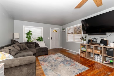 Living room featuring dark wood finished floors and a ceiling fan