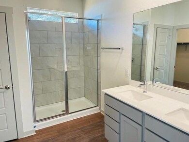 Bathroom with a shower stall, wood finished floor