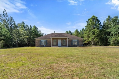 Single story home with a front lawn and brick siding