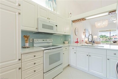 Kitchen with white appliances, a sink, a chandelier, and light countertops