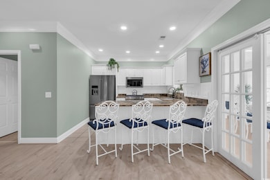 Kitchen with crown molding, a breakfast bar area, 