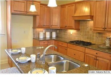 The kitchen has beautiful glazed cabinets, granite