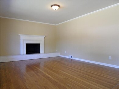 Wood Burning Fireplace with Marble & Brick Hearth in Living Room.  Gleaming Wood Floors, recently done.