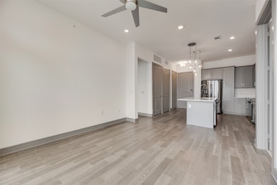 Unfurnished living room with recessed lighting, light wood-style flooring, a chandelier, and ceiling fan