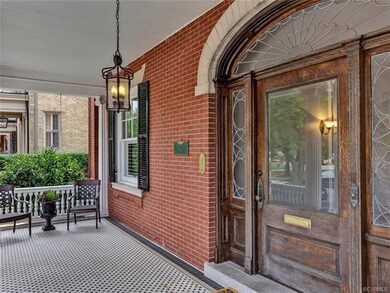Tiled front portico - perfect for entertaining guests or watching the 10K  - and beautiful leaded glass fan transom over front door.