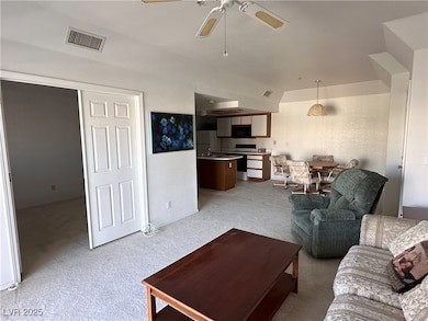 Living area featuring visible vents, a ceiling fan
