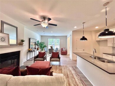 Living area with wood finished floors, recessed lighting, a ceiling fan, a glass covered fireplace, and baseboards