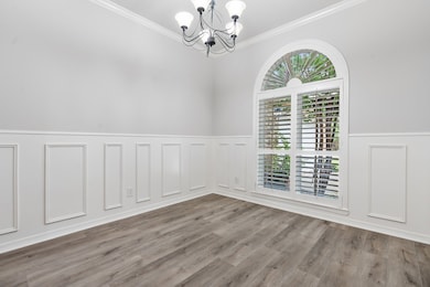 This room features elegant wainscoting, a brick ac