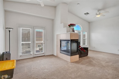 Carpeted living area with baseboards, ceiling fan,