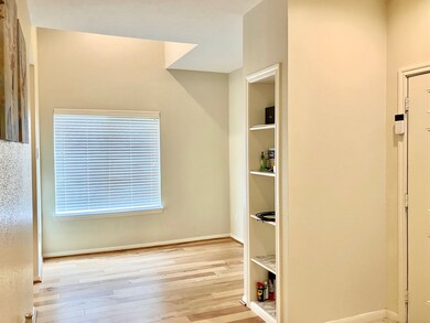 Study area with heigh ceiling and a build in bookc