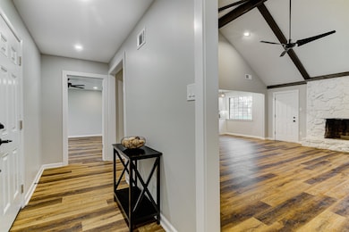Hall with baseboards, visible vents, wood finished