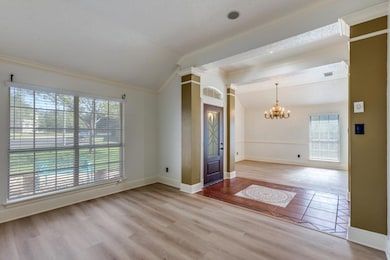 Spare room with vaulted ceiling, light wood-style