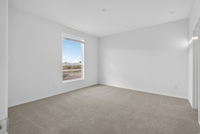 Spare room with light colored carpet and baseboards