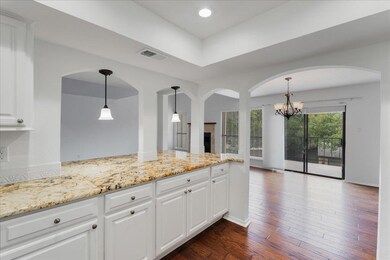 Kitchen with a chandelier, light stone counters, 
