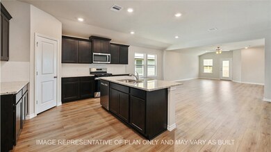Kitchen featuring light stone countertops, sink, a