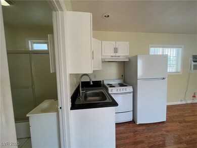 Kitchen with a sink, white appliances, under cabin