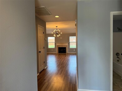 Hallway featuring dark hardwood / wood-style floors and a chandelier