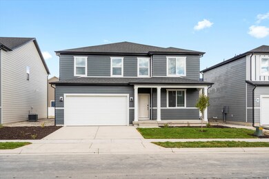 Traditional-style house with roof with shingles, concrete driveway, covered porch, and a garage