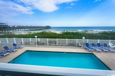 Pool with fence, a water view, and a patio