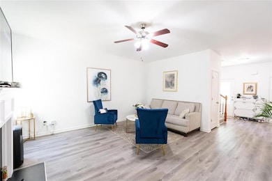 Living room with baseboards, a ceiling fan, and wo