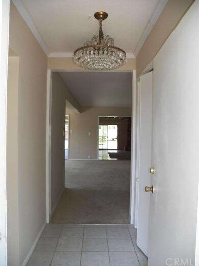 Elegant tiled entry way with chandelier with laund