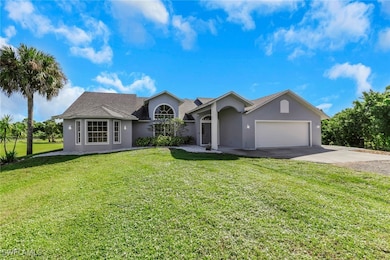 Single story home featuring stucco siding, concrete driveway, a front yard, and an attached garage