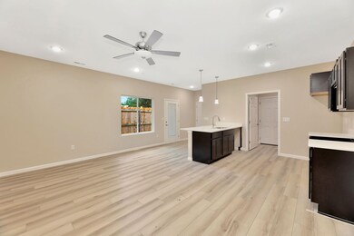 Kitchen with a peninsula, hanging light fixtures, open floor plan, light wood-style floors, and recessed lighting