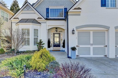 View of front of home featuring brick siding, a garage, and driveway