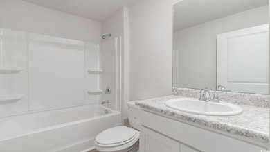 Full bathroom featuring vanity, toilet, and shower