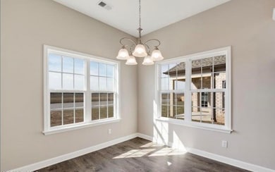 Unfurnished dining area with a chandelier and dark wood-type flooring