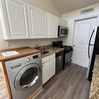 Kitchen with visible vents, washer / dryer, stain