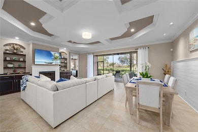Living room featuring coffered ceiling, light tile patterned floors, ornamental molding, and NEW LED recessed lighting