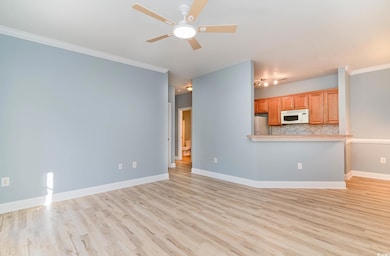 Unfurnished living room featuring crown molding, l