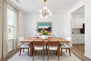 Dining area featuring light wood finished floors, ornamental molding, and a chandelier