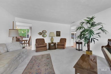 Carpeted living area featuring a chandelier