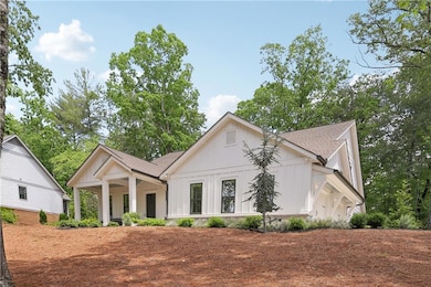 Modern farmhouse style home featuring a shingled roof and board and batten siding