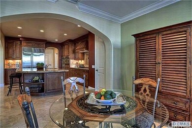 Dining nook with crown molding and opens to covere