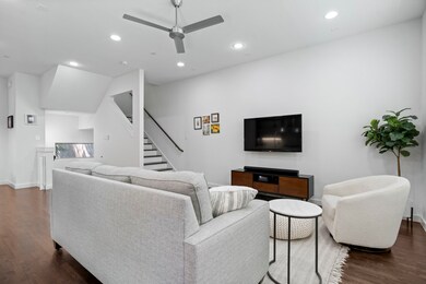 Living area featuring dark wood-type flooring, a ceiling fan, recessed lighting, and stairway