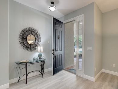 Foyer entrance with light wood-type flooring and baseboards