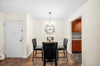 Dining room with a chandelier, stone finish floors, and a baseboard radiator
