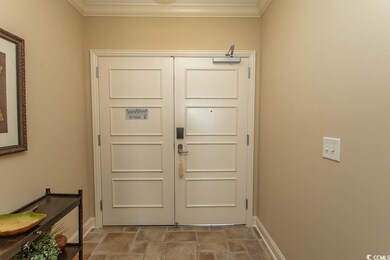Entryway featuring stone finish flooring, ornamental molding, and baseboards