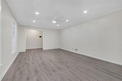 Spare room with a ceiling fan, ornamental molding, recessed lighting, wood finished floors, and baseboards