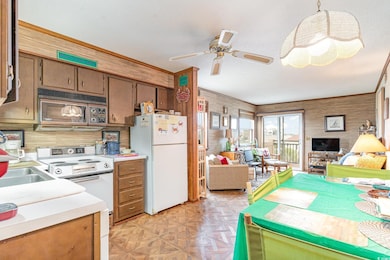 Kitchen featuring ceiling fan, sink, white applian