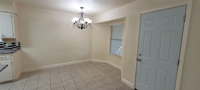 Breakfast area with chandelier and tile floor.
